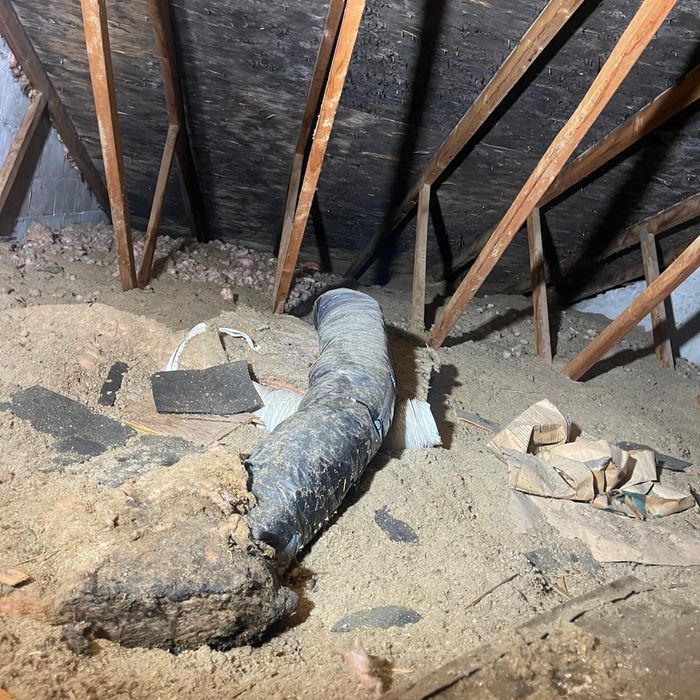 Old ducting and loose-fill insulation in an attic